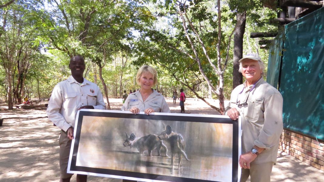 We presented several pieces of art featuring painted dogs to the conservation Center